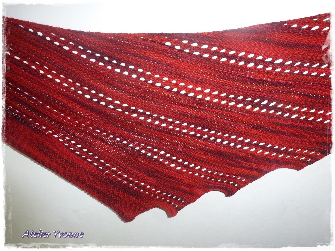 Rotes Dreieckstuch mit regelmäßigen Ajourlöchern und gewelltem Saum
