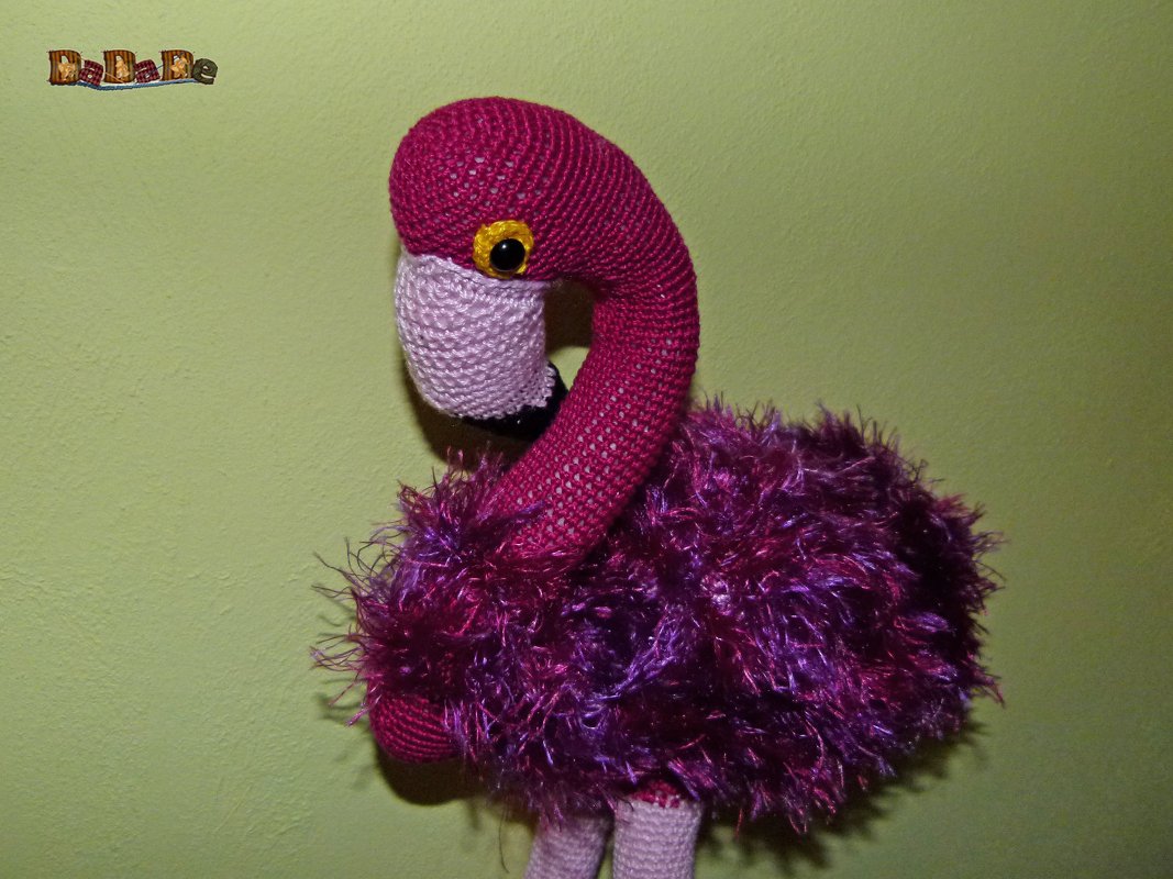 Gehäkelter Flamingo-Amigurumi mit pinkem Kopf, helllila Schnabel und flauschigem pink-lila Körper