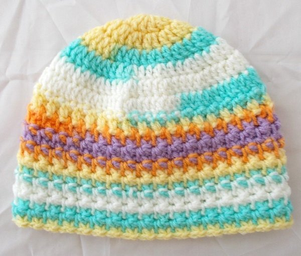 Textur einer gehäkelten Babymütze mit horizontalen, pastelligen Streifen