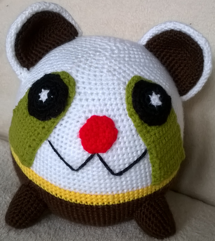 Rundes Amigurumi mit gesticktem Mund, roter Nase und braunem Körper