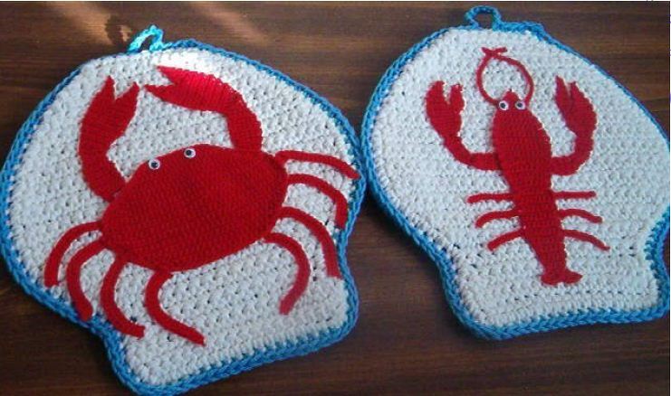 Crochet potholders with red crab and lobster designs and blue edging