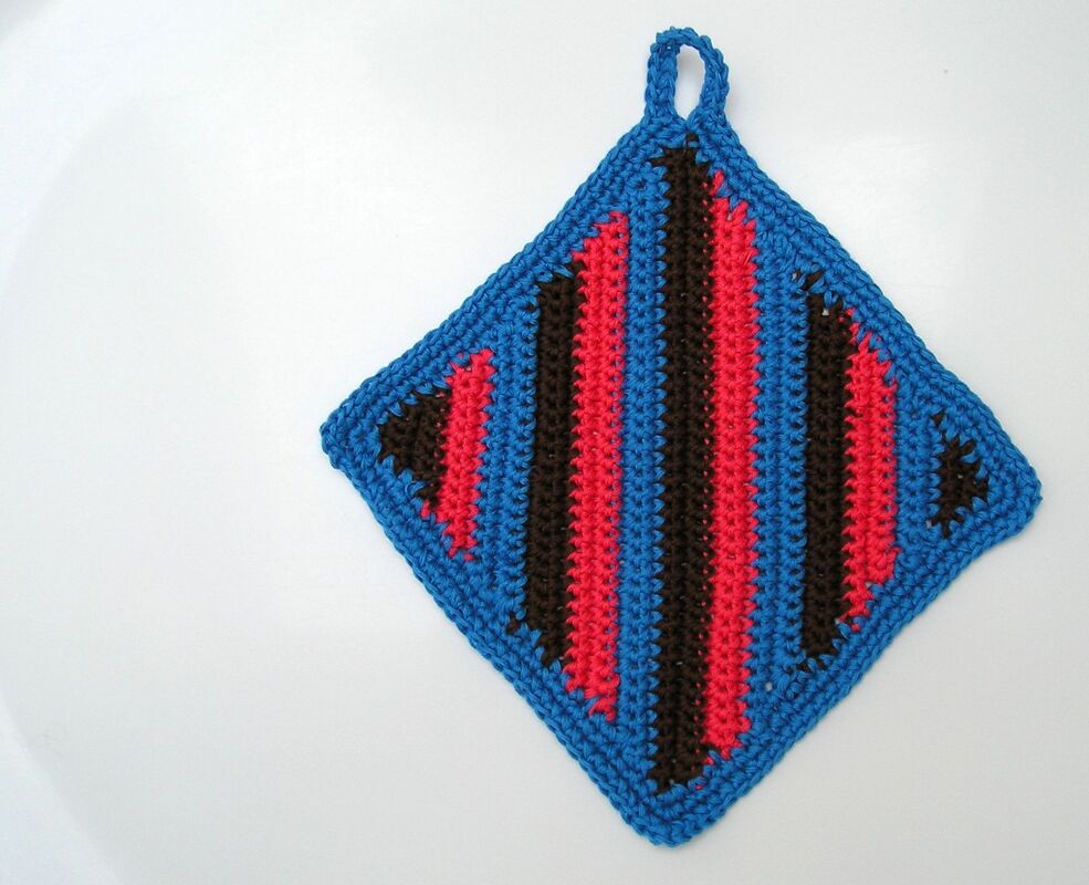 Gehäkelter, rautenförmiger Topflappen mit blauem Rand und rot-dunkelbraunen Streifen, mit Aufhängeschlaufe.