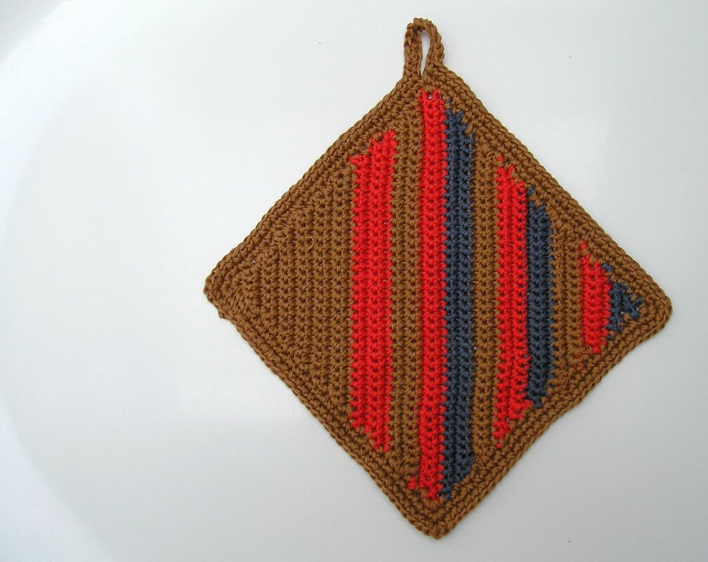 Gehäkelter quadratischer Topflappen in Braun mit roten und blauen Streifen und Aufhängeschlaufe auf weißem Hintergrund.