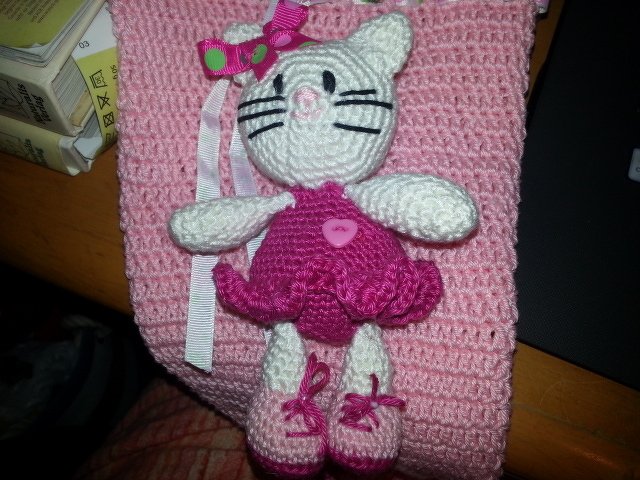 Gehäkelte weiße Amigurumi-Katze mit rosa Kleid, Schleife und Schuhen