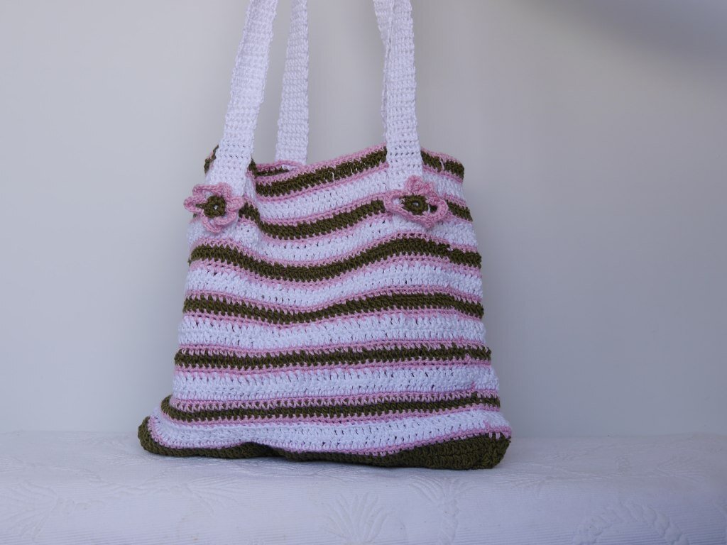 Gehäkelte Umhängetasche mit weiß-rosa-olivgrünen Streifen und Blumenapplikationen