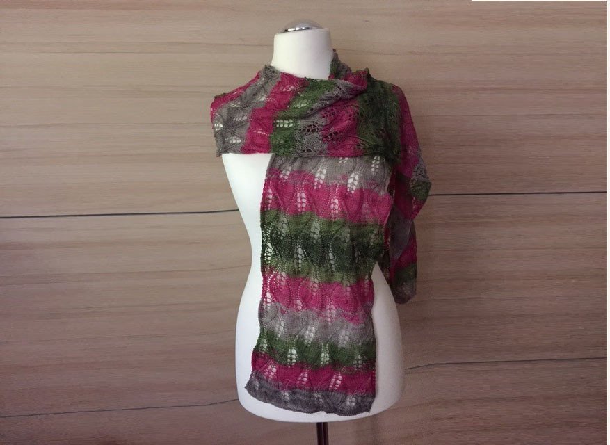 Gestrickter Schal mit pinken, grünen und grauen Streifen und Lochmuster an einer Schaufensterpuppe