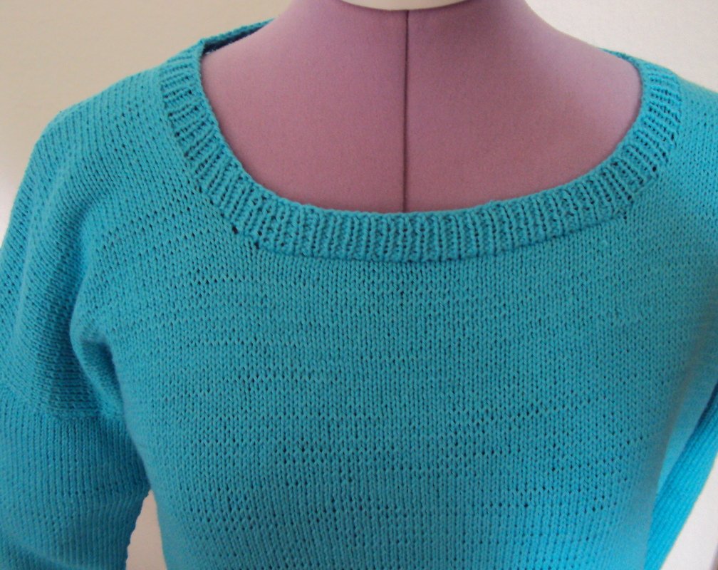 Türkiser Strickpullover auf Schneiderpuppe mit Rippbündchen am Halsausschnitt