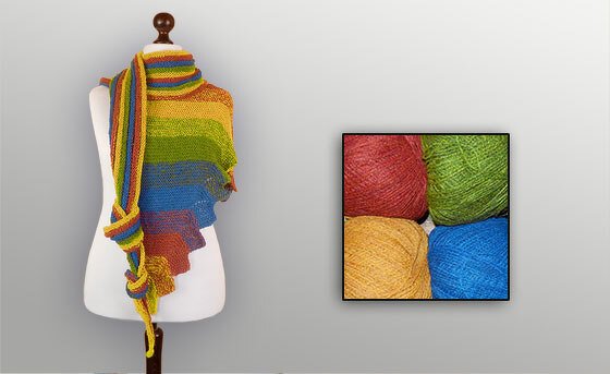 Gestricktes Dreieckstuch mit bunten Streifen auf einer Schneiderpuppe und vier farbige Garnknäuel