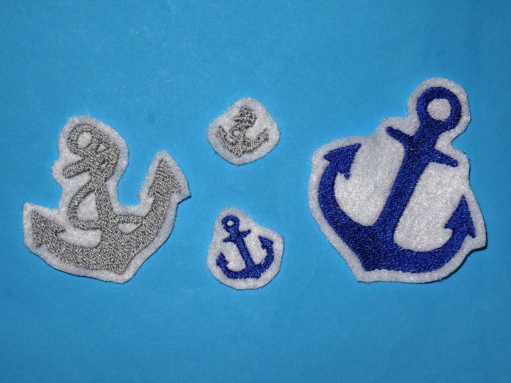 Vier bestickte Ankerapplikationen in Blau und Silber auf blauem Stoff