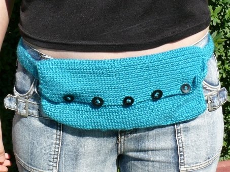 Türkis gehäkelte Gürteltasche mit schwarzer Knopfleiste über Jeans