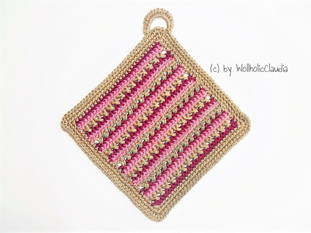 Quadratischer gehäkelter Topflappen in Rosa, Pink und Natur mit diagonalen Streifen und Aufhängeschlaufe auf weißem Hintergrund