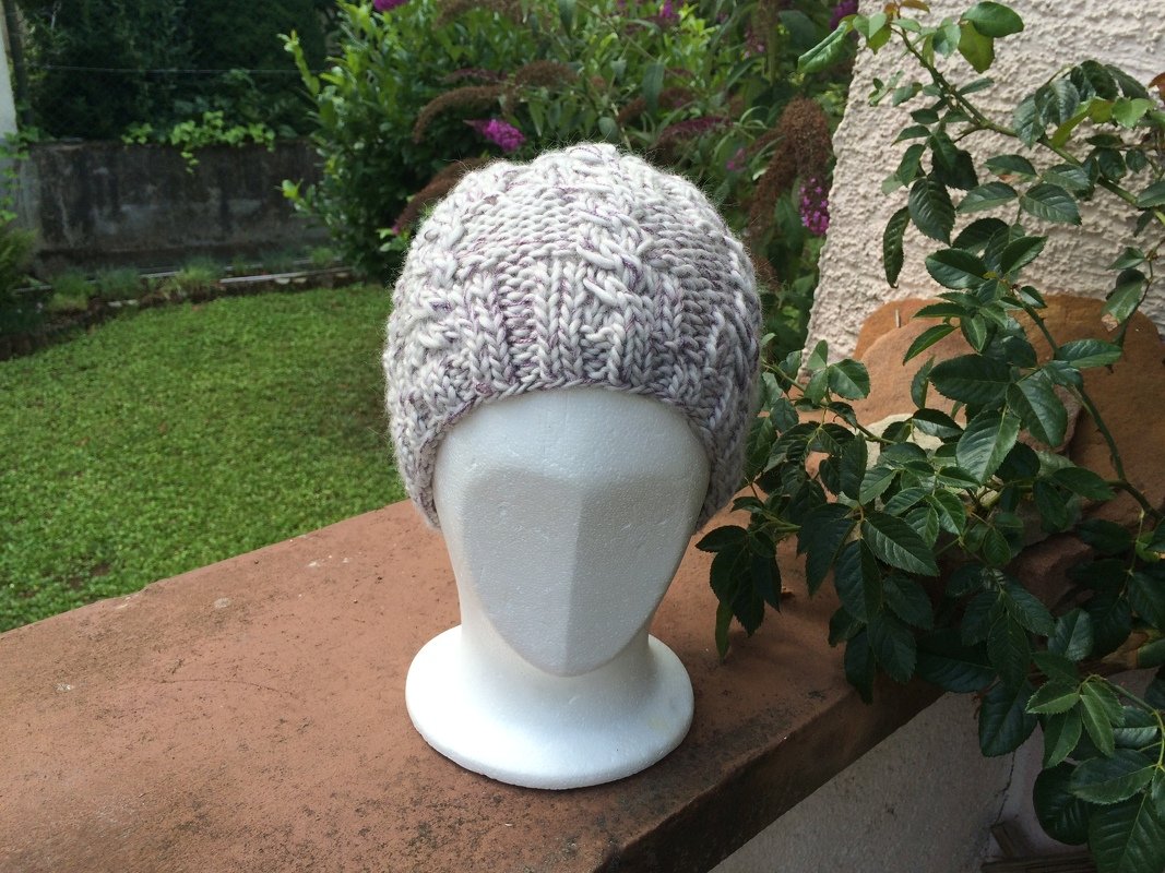 Gestrickte Mütze mit Zopfmuster in Grau-Lila auf weißem Kopfmodell
