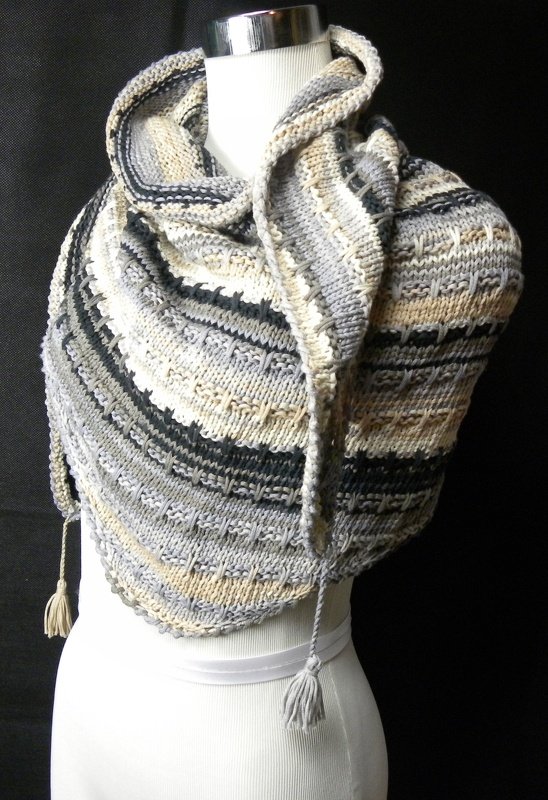 Gestricktes Dreieckstuch in Grau-, Beige- und Schwarztönen mit Quasten auf einer Schneiderpuppe