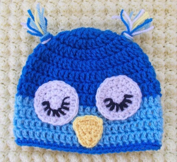 Gehäkelte Eulen-Babymütze blau und hellblau mit applizierten Augen, gestickten Wimpern und gelbem Schnabel