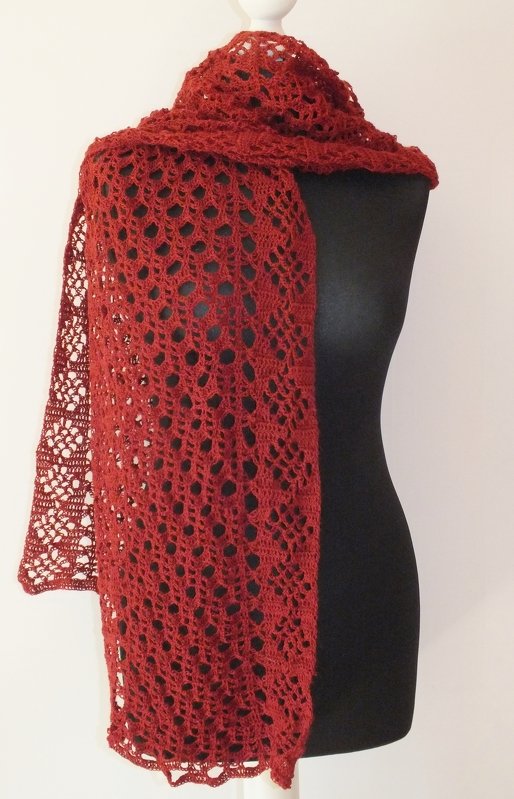 Rostrotes, gehäkeltes Rechtecktuch mit Ajourmuster auf schwarzer Schneiderbüste drapiert