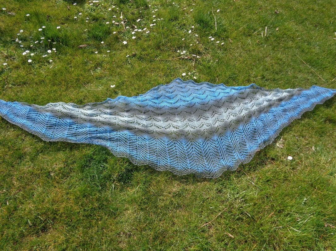 Gestricktes Dreieckstuch Blau-Grau mit Lochmuster auf Gras