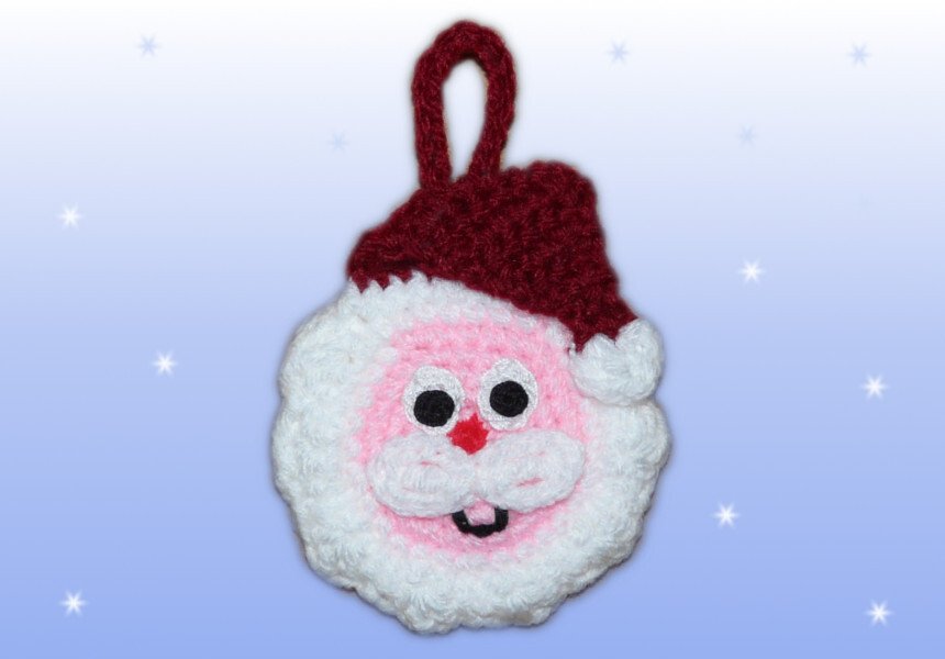 Gehäkeltes Weihnachtsmann-Gesicht mit roter Mütze und Aufhängeschlaufe