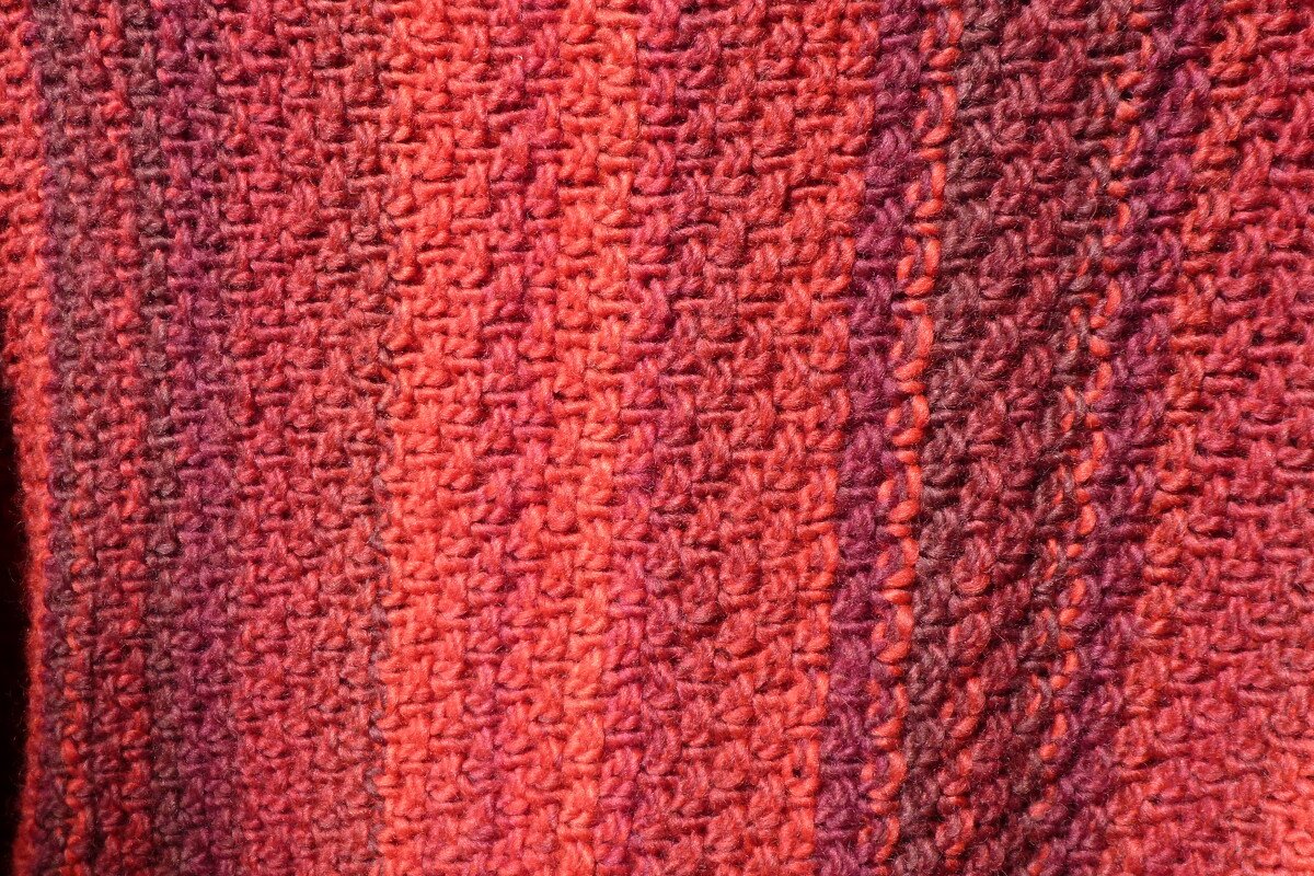 Nahaufnahme gestrickter Pullover in Rot mit strukturiertem Maschenbild