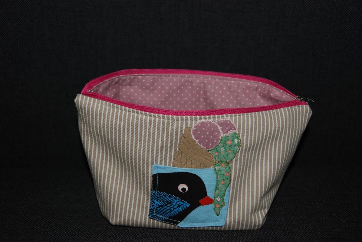 Gestreifte Kosmetiktasche mit pinkem Reißverschluss, gepunktetem Innenfutter und Vogel-/Eis-Applikation