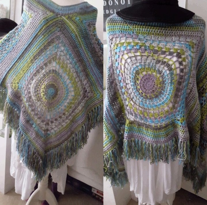 Gehäkelter Damenponcho mit zentralem Quadratmuster und Fransen in Grau, Blau, Grün und Lila auf Schaufensterpuppe