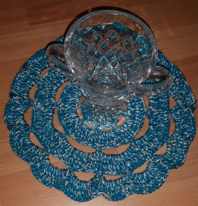 Blau-silberner gehäkelter Untersetzer mit ringförmigem Muster