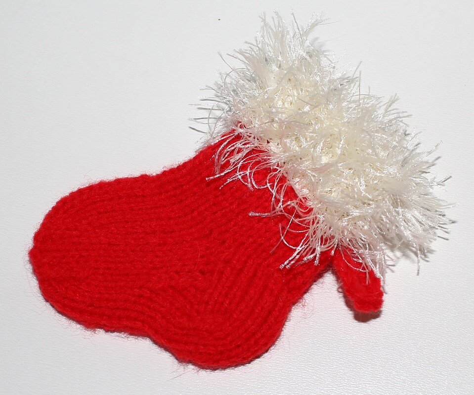 Roter gestrickter Mini-Weihnachtsstiefel mit weißem flauschigem Rand