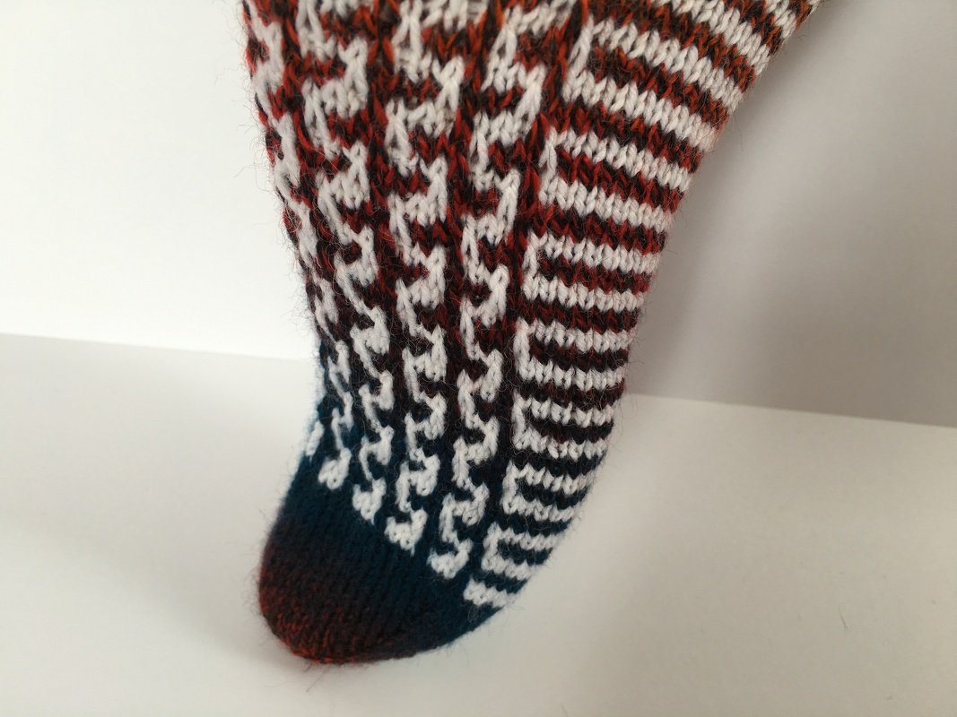 Detailaufnahme der Sockenspitze mit zweifarbigen Streifen und sichtbarem Maschenbild