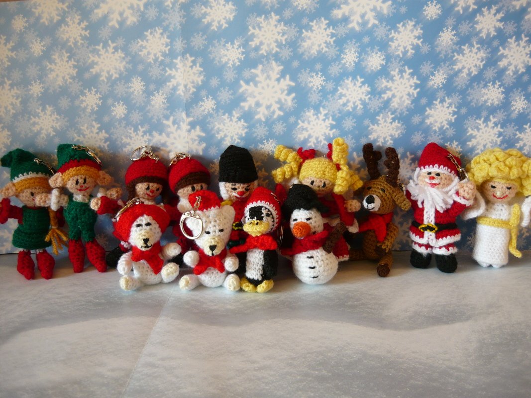 Bunte gehäkelte Weihnachtsfiguren als Dekoration: Elfen, kleine Bären, Pinguin, Schneemann, Rentier, Weihnachtsmann und Engel