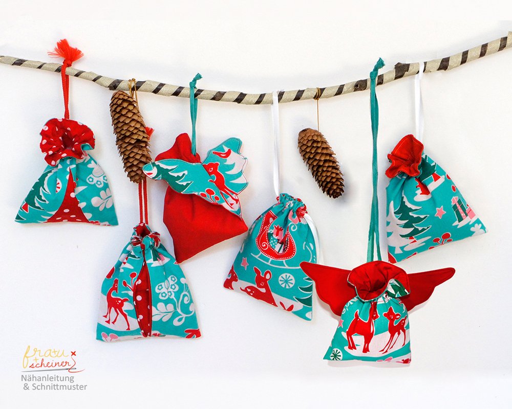 Genähte Weihnachtsbeutel in Rot und Türkis mit Rentier- und Tannenbaum-Motiven an einer Kordel