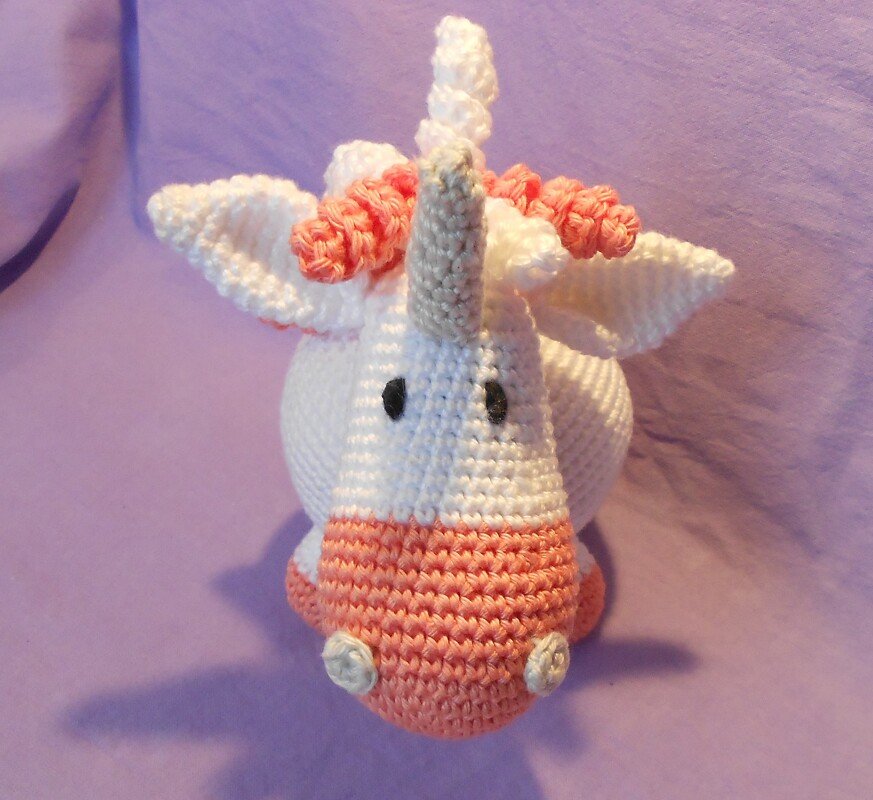 Gehäkeltes Amigurumi-Einhorn weiß mit rosa Schnauze und Horn
