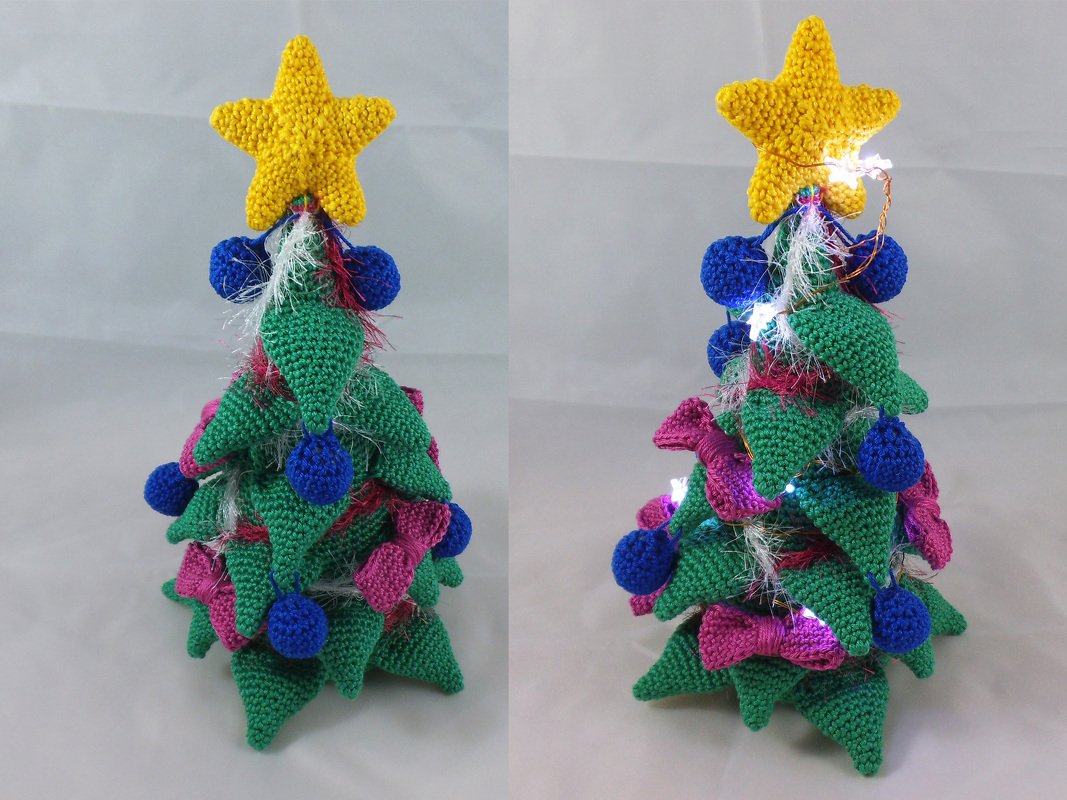 Gehäkelter Mini-Weihnachtsbaum mit gelbem Stern, blauen Kugeln, rosa Schleifen und Lichterkette