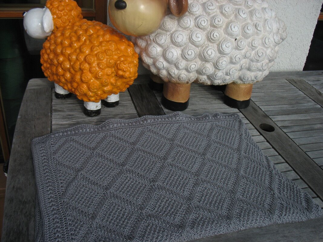 Gestrickte graue Babydecke mit Rautenmuster und detailliertem Rand