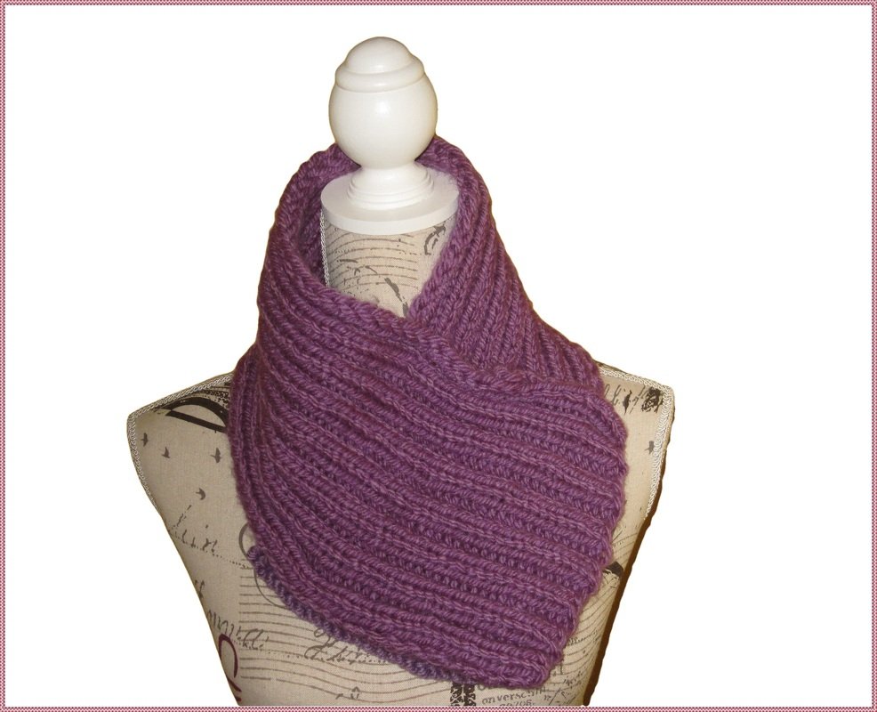 Lila gestrickter Loop-Schal mit Rippenmuster auf einer beigen Schneiderbüste