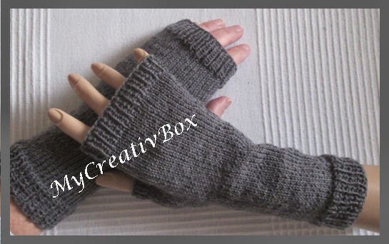 Graue gestrickte fingerlose Handschuhe mit Rippbündchen auf Handmodell