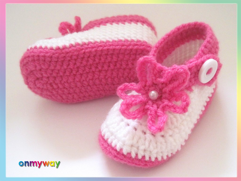 Gehäkelte weiße und pinke Babyschuhe mit Riemchen, Knopf und Blüte