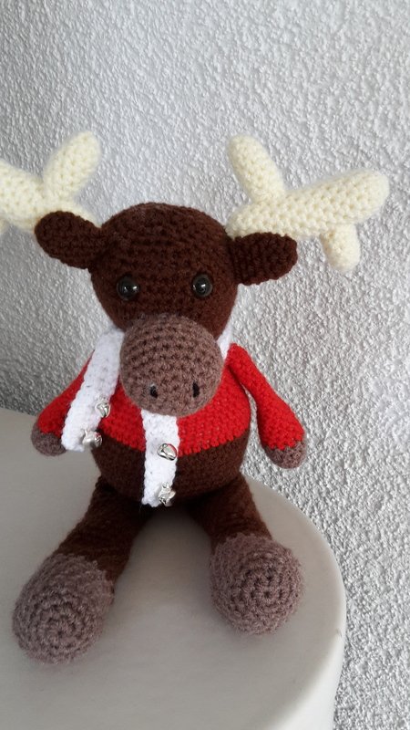 Braunes Rentier-Amigurumi mit rotem Pullover und weißem Schal