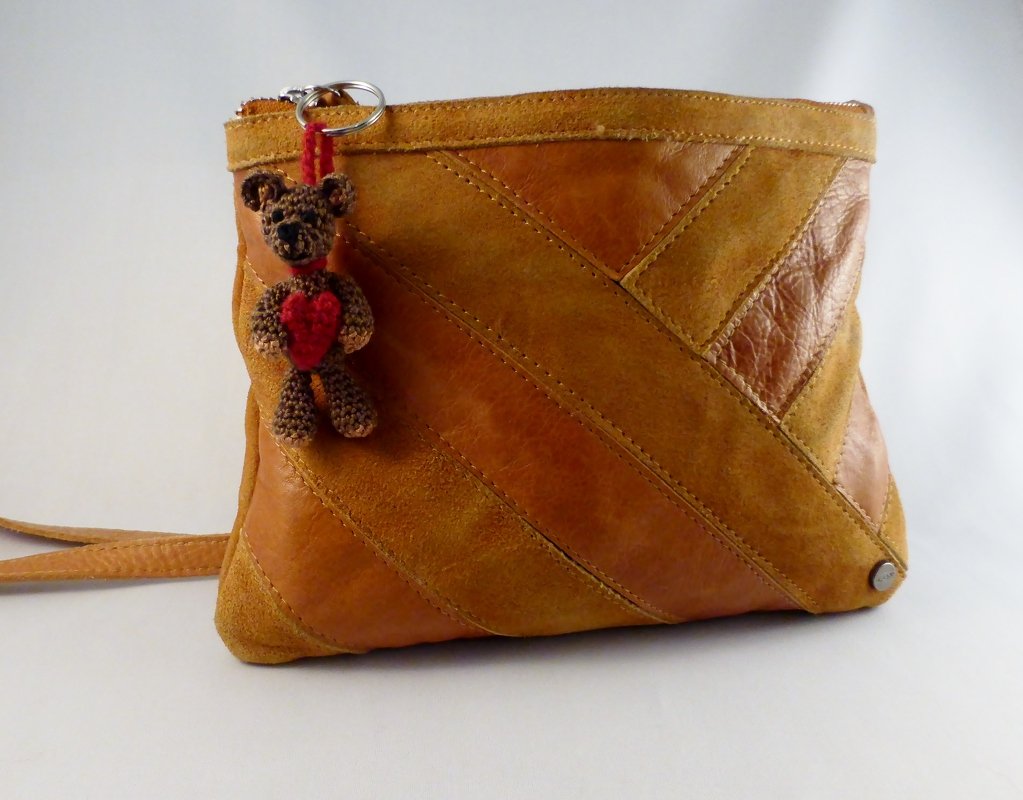 Gehäkelter brauner Teddybär-Schlüsselanhänger mit rotem Herz an einer hellbraunen Tasche