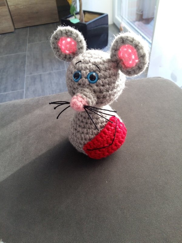Gehäkelte graue Maus mit rosa Ohren und roter Applikation