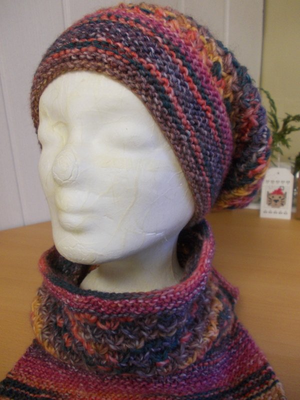 Vorderansicht gestrickter Slouch‑Mütze und Schlauchschal an einem Schaufensterkopf