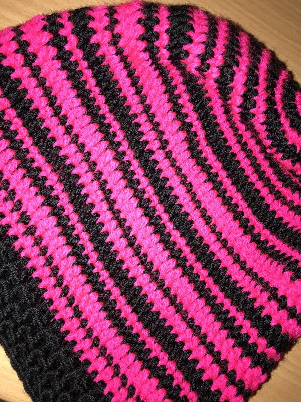 Gehäkelte Kinderbeanie mit schwarz‑neonpinken Streifen und breitem Rippenbund