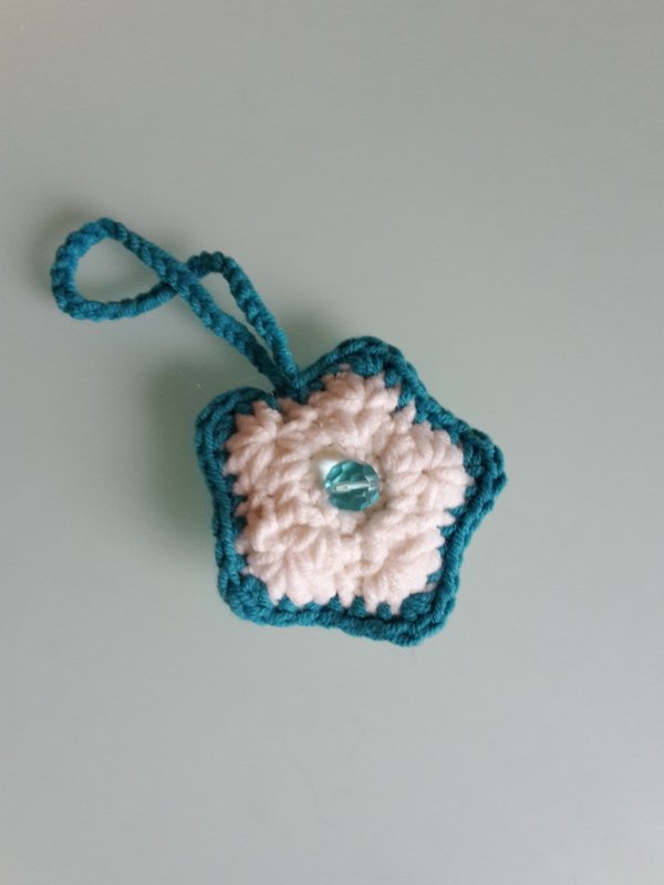 Gehäkelter sternförmiger Anhänger weiß und türkis mit Perle und Aufhängeschlaufe