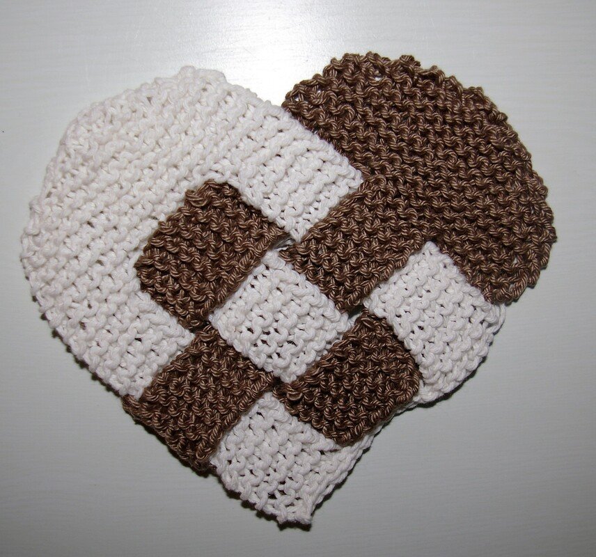 Gestricktes Herz in geflochtener Optik, weiß und braun, auf hellem Hintergrund
