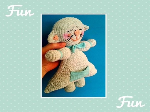 Detailansicht einer gehäkelten Amigurumi-Katze mit Fokus auf Maschen, gestickten Details und Tasche