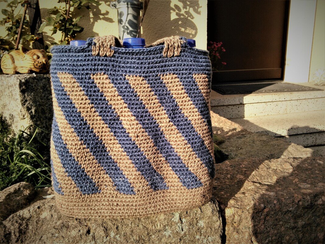 Rechteckige gehäkelte Henkeltasche mit kurzen Griffen und diagonalen blauen und beigen Streifen