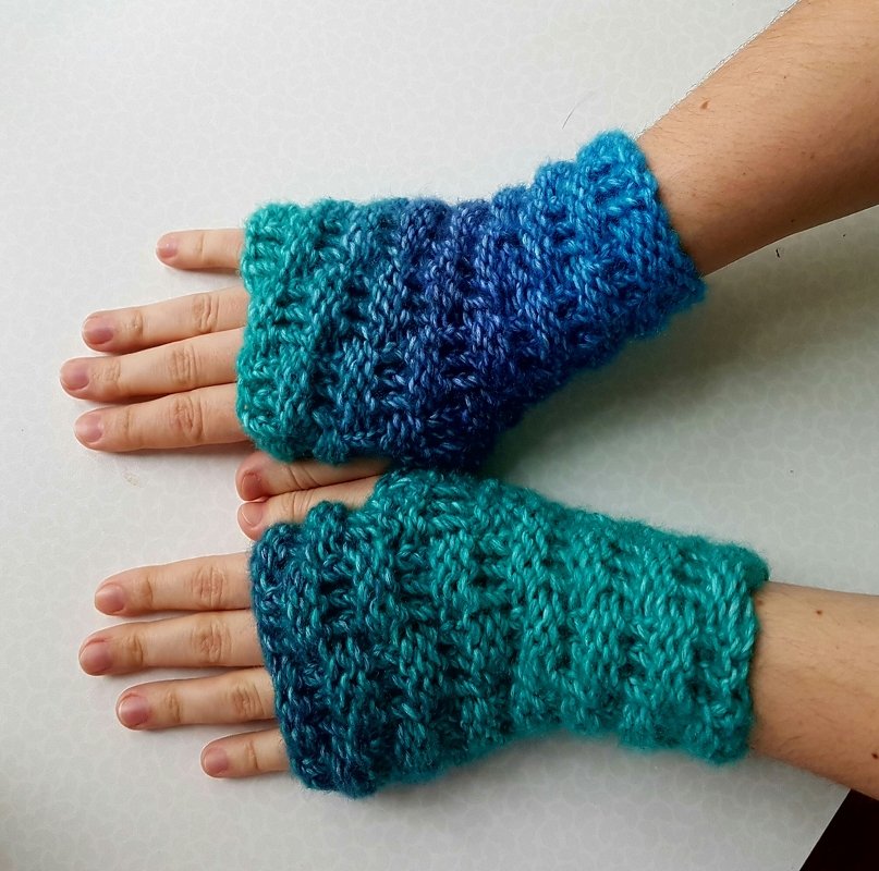 Fingerlose Armstulpen mit türkis-blauem Farbverlauf an beiden Händen