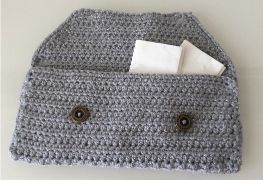 Gehäkelte graue Clutch mit Umschlag und zwei Knöpfen, Taschentuch sichtbar