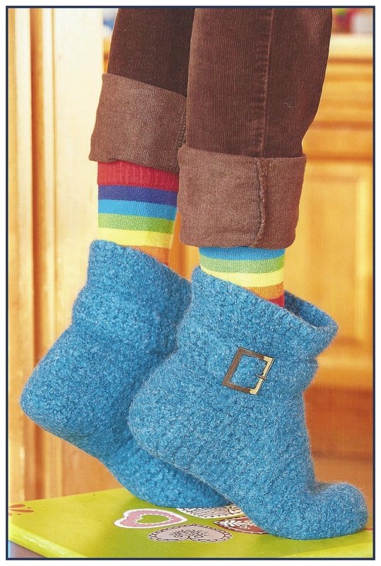 Hellblaue gefilzte Hausschuhe mit Schnalle, getragen mit bunten Socken und hochgekrempelter Hose.