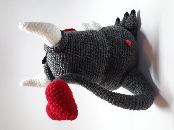 Amigurumi Teufelchen in Grau mit weißen Hörnern und rotem Herz