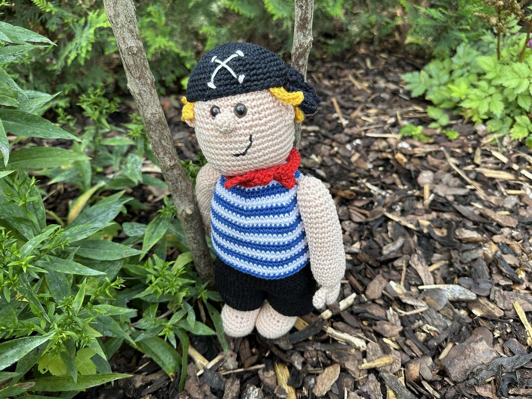 Nahaufnahme gehäkelte Amigurumi-Puppe mit Ringelshirt und Kopftuch