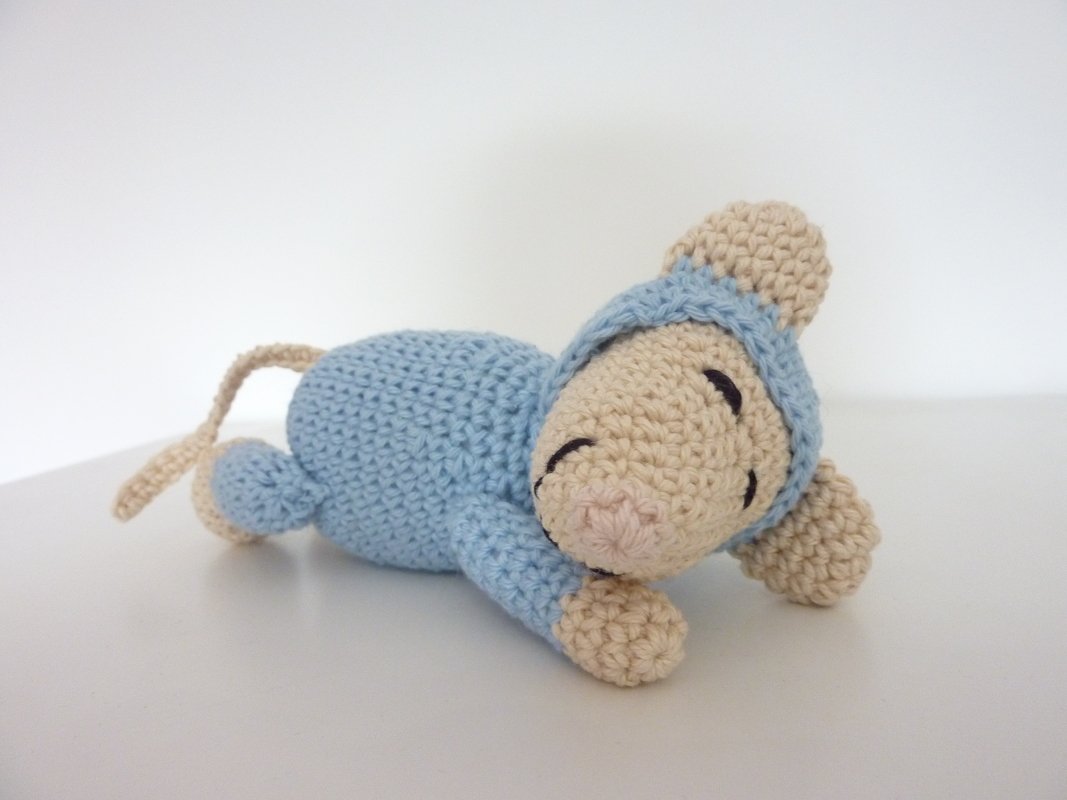 Gehäkelte Amigurumi-Maus liegend in Beige und Hellblau